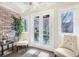 Inviting sun room with French doors, brick accent wall, and natural light at 2840 Peachtree Nw Rd # 301, Atlanta, GA 30305