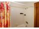 Bathroom with a white tiled shower, bright colored curtain, and chrome shower head at 4995 Greentree Trl, College Park, GA 30349