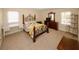 Cozy bedroom with decorative iron bedframe, wood dresser, desk, and natural light from two windows at 4995 Greentree Trl, College Park, GA 30349