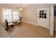 Bright dining area features modern lighting, glass table, and wood flooring near a door and large windows at 4995 Greentree Trl, College Park, GA 30349