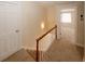 Hallway with carpeted stairs, white railing, and views of a bedroom with natural light at 4995 Greentree Trl, College Park, GA 30349