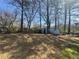 Large backyard with green space, mature trees, and a storage shed at 5872 Fox Run, Rex, GA 30273