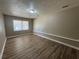 Neutral bedroom featuring wood-look floors, a window, and a flush-mounted light fixture at 5872 Fox Run, Rex, GA 30273