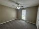 Bedroom with plush carpeting, ceiling fan, and natural light from the window at 5872 Fox Run, Rex, GA 30273