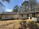 Exterior rear view of the house showing the sunroom addition, and a large, open backyard at 5872 Fox Run, Rex, GA 30273