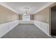Formal dining room with classic wainscoting, neutral paint, plush carpet, and chandelier at 81 Sheffield Ln, Powder Springs, GA 30127