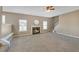 A cozy living room with carpet, a fireplace, a ceiling fan, and staircase to the upper level at 81 Sheffield Ln, Powder Springs, GA 30127