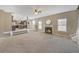 A living room features a fireplace, carpet, a ceiling fan, and a view to the kitchen at 81 Sheffield Ln, Powder Springs, GA 30127
