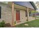 Charming brick home featuring a welcoming front porch with wooden support beams and a modern red front door at 1246 Bell Ave, East Point, GA 30344