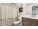 Nicely decorated bathroom with a white and grey shower curtain, updated vanity, and decorative wall fixtures at 1570 Halbrook Pl, Marietta, GA 30008