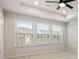 Bright bedroom with tray ceiling, fan, and three large windows offering neighborhood views at 1570 Halbrook Pl, Marietta, GA 30008