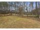 Fenced backyard featuring a large grassy area and mature trees, offering privacy and space at 4975 Rockstone Way, Acworth, GA 30101