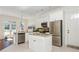 Eat-in kitchen featuring an island, stainless appliances, white cabinetry, and access to a patio at 1518 Robins Walk, Alpharetta, GA 30005