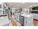 Open-concept kitchen flows into the living area, featuring white cabinets, a large island, and stainless appliances at 2456 Hidden Creek Rd, Kennesaw, GA 30152