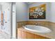 Bathroom featuring large soaking tub with tile surround and artistic wall decor at 825 Highland Ln # 1105, Atlanta, GA 30306