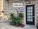 Front entrance of building showing stone façade, small garden, and black door with glass panes at 825 Highland Ln # 1105, Atlanta, GA 30306
