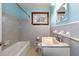 Cozy bathroom featuring grey tiled walls, a white vanity, and natural light at 3406 Woodview Se Dr, Smyrna, GA 30082