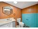 Bathroom featuring wood paneling, bright teal tiles and a vanity with an oval mirror at 3406 Woodview Se Dr, Smyrna, GA 30082