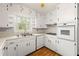 Functional kitchen with white cabinetry, laminate counters, and updated appliances plus a ceiling fan at 3406 Woodview Se Dr, Smyrna, GA 30082