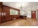 Bright kitchen and dining area with wood-paneled walls, hardwood floors, and white cabinets at 3406 Woodview Se Dr, Smyrna, GA 30082