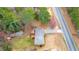 An aerial view of a home featuring a deck, shed, and fire pit, surrounded by lush trees and a nearby road at 4480 Highway 5, Douglasville, GA 30135