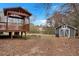 A backyard featuring a wooden deck with a canopy and a small storage shed with a unique window design at 4480 Highway 5, Douglasville, GA 30135