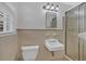 Classic bathroom features a white toilet, sink, and shower with glass door at 4480 Highway 5, Douglasville, GA 30135