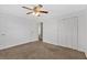 This bedroom features neutral carpet, a ceiling fan, and a closet for storage at 4480 Highway 5, Douglasville, GA 30135