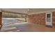 A well-lit carport with brick accents, a doorway, and partial view of a driveway with a roadside American flag at 4480 Highway 5, Douglasville, GA 30135