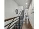 Stairway and hallway featuring hardwood floors, metal railing, white walls and a view into the kitchen at 105 City View Ne Ct, Atlanta, GA 30308