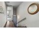 Hallway with hardwood floors, staircase, metal railing, and artwork leading to bedroom at 105 City View Ne Ct, Atlanta, GA 30308