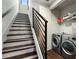 Modern staircase with dark wood steps leading to the laundry area featuring stainless steel machines at 105 City View Ne Ct, Atlanta, GA 30308