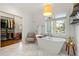 Bright bathroom featuring marble floors, soaking tub, and a nearby walk-in closet at 1181 Fairview Ne Rd, Atlanta, GA 30306