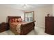 Comfortable bedroom with a wooden bed frame, bedside table, and dresser, flooded with natural light at 1274 Creek Laurel Dr, Lawrenceville, GA 30043