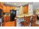 Functional kitchen with wood cabinetry, black appliances, and a cozy breakfast bar at 1274 Creek Laurel Dr, Lawrenceville, GA 30043