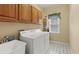 Practical laundry room with a utility sink, overhead cabinets, and a white washer and dryer at 1274 Creek Laurel Dr, Lawrenceville, GA 30043