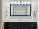 Stylish bathroom featuring a blue vanity, white marble countertop, and well-lit mirror at 24308 Plantation Ne Dr, Atlanta, GA 30324