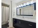 Modern bathroom featuring blue vanity with marble countertop, stylish mirror, and walk-in shower at 24308 Plantation Ne Dr, Atlanta, GA 30324