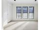 Neutral living space with three large windows, white door, and plush carpeting at 24308 Plantation Ne Dr, Atlanta, GA 30324