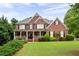 Charming brick home with manicured lawn, covered porch, and lush landscaping at 235 Rippling Nw Dr, Marietta, GA 30064