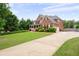 Charming brick home with manicured lawn, long driveway, and mature trees at 235 Rippling Nw Dr, Marietta, GA 30064