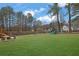 Spacious backyard featuring a playset, lush lawn, and mature trees, perfect for outdoor activities at 3135 Nectar Dr, Powder Springs, GA 30127