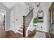 Welcoming entryway with a wooden staircase, decorative mirror, and stylish lighting fixture at 3135 Nectar Dr, Powder Springs, GA 30127