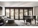 Elegant living room featuring a grand piano, plush seating, and large windows for natural light at 437 Hollydale Nw Ct, Atlanta, GA 30342