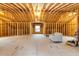 Unfinished attic with exposed wood framing, a window, a sofa and a decorated box at 5322 Seaton Dr, Dunwoody, GA 30338