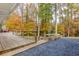 Wooden deck with railings overlooking colorful trees, with a gravel area and a built-in bench at 5322 Seaton Dr, Dunwoody, GA 30338