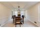 Formal dining room with a dark wood table, chair rail detail, and modern light fixture at 5322 Seaton Dr, Dunwoody, GA 30338