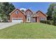 Charming two-story brick home with a well-manicured lawn and attached two-car garage at 1665 Windsong Park Dr, Dacula, GA 30019