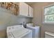 Bright laundry room with modern washer and dryer units at 1665 Windsong Park Dr, Dacula, GA 30019