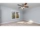 Carpeted bedroom features a ceiling fan and a window offering natural light at 2001 Towne Lake W Hls, Woodstock, GA 30189